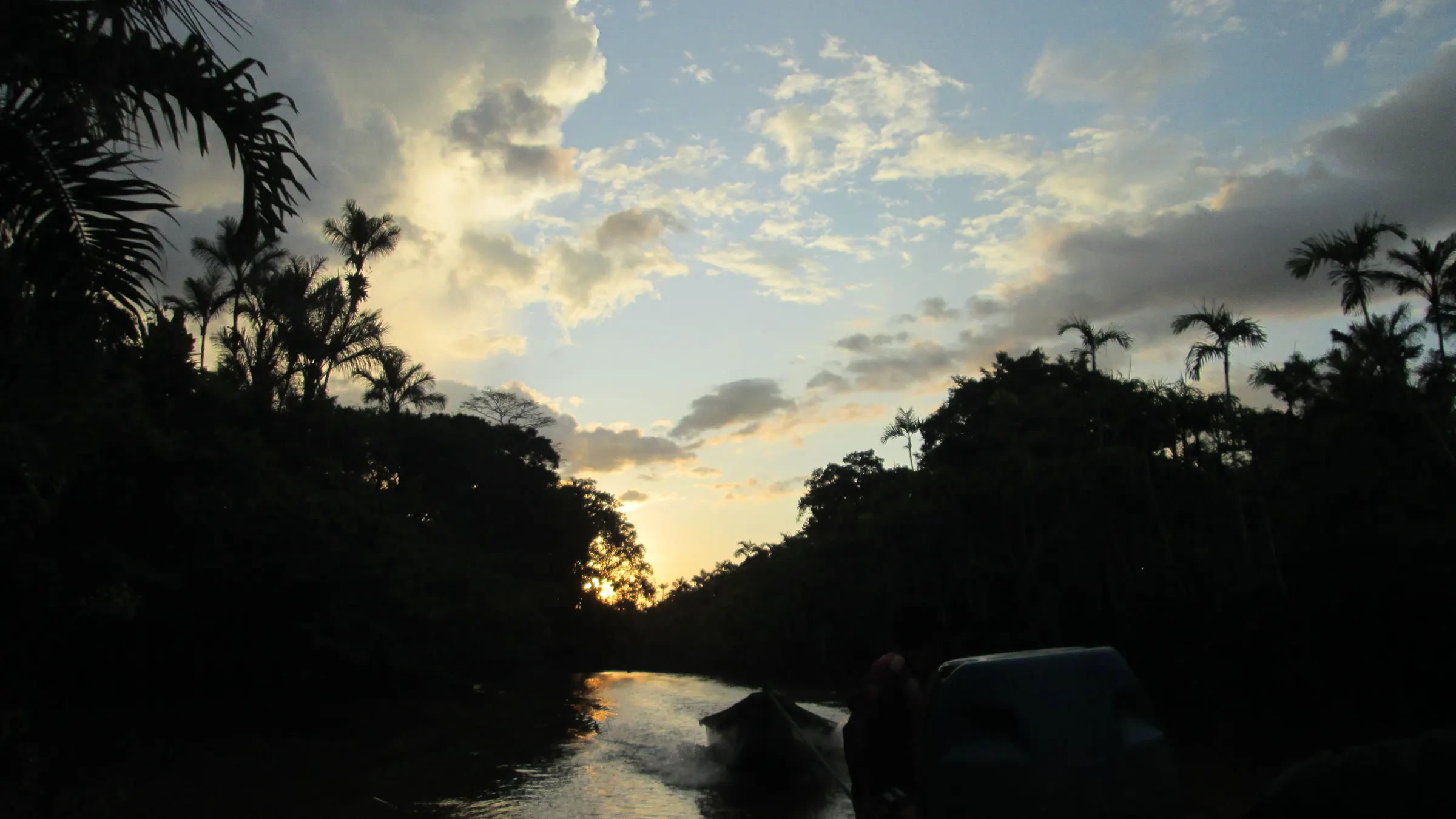 Atardecer sobre un río de la Amazonía ecuatoriana, con la silueta de las palmeras recortada contra el cielo encendido